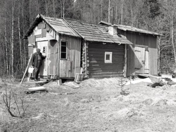 En stuga i skogen är påbyggd två gånger från den ursprungliga timrade stugan.