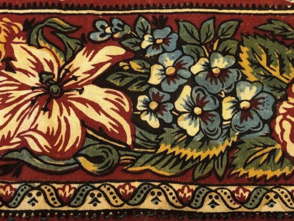 Tryckt blomstermönster i rött, gult och grönt på kattun från Bjuråker