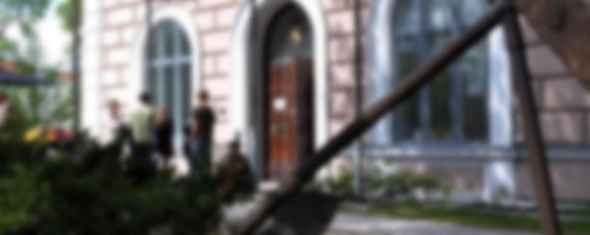 Museets huvudentŕe med en grupp personer ståendes utanför. I förgrunden skymtas ankaret som står invid Storgatan i Hudiksvall.