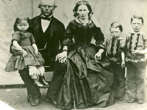 Ett familjefoto där endast kvinnan ser glad ut och de övriga visar upp sura miner.