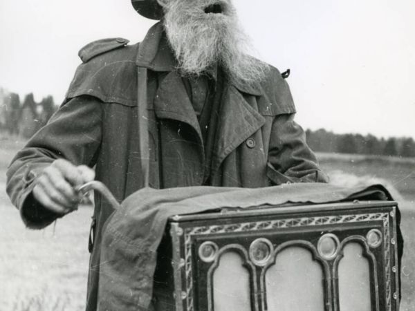 En positivspelare sjunger och vevar på sin positiv.